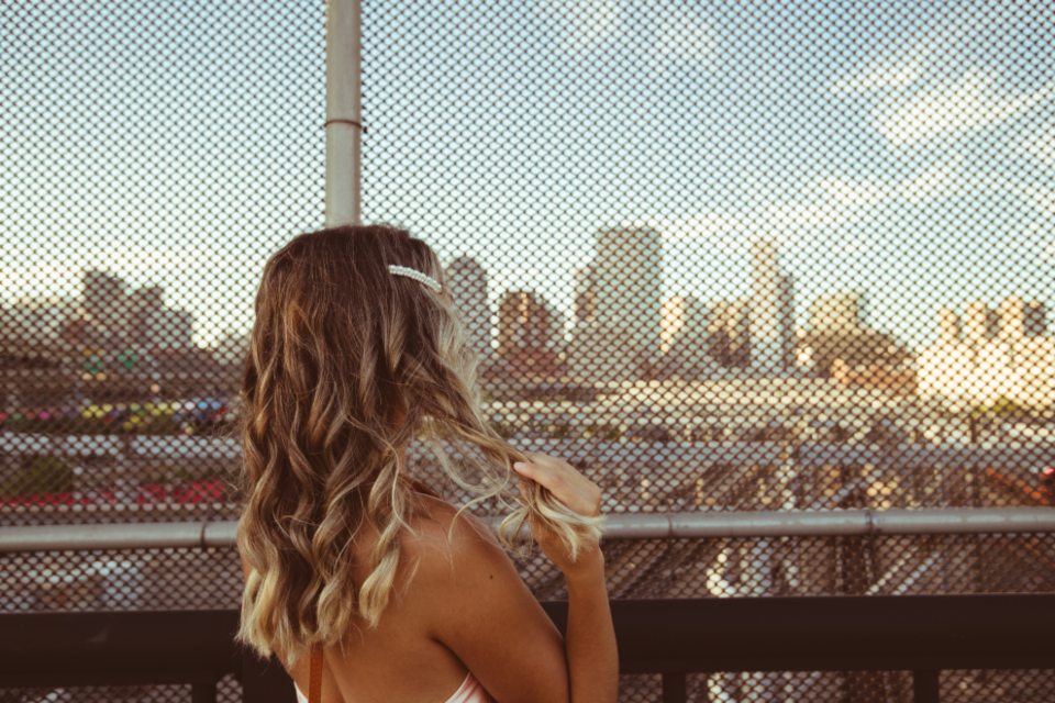 Cabelo longo e ondulado com pontas mais claras, visto de costas