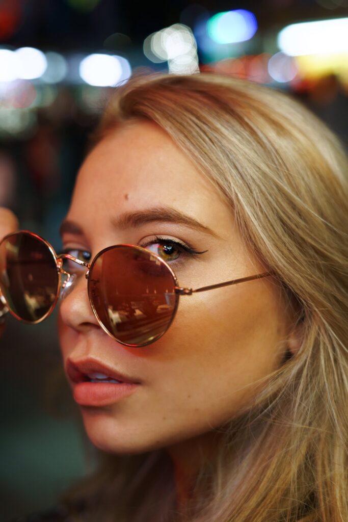 Close de mulher com cabelo loiro dourado e óculos de sol