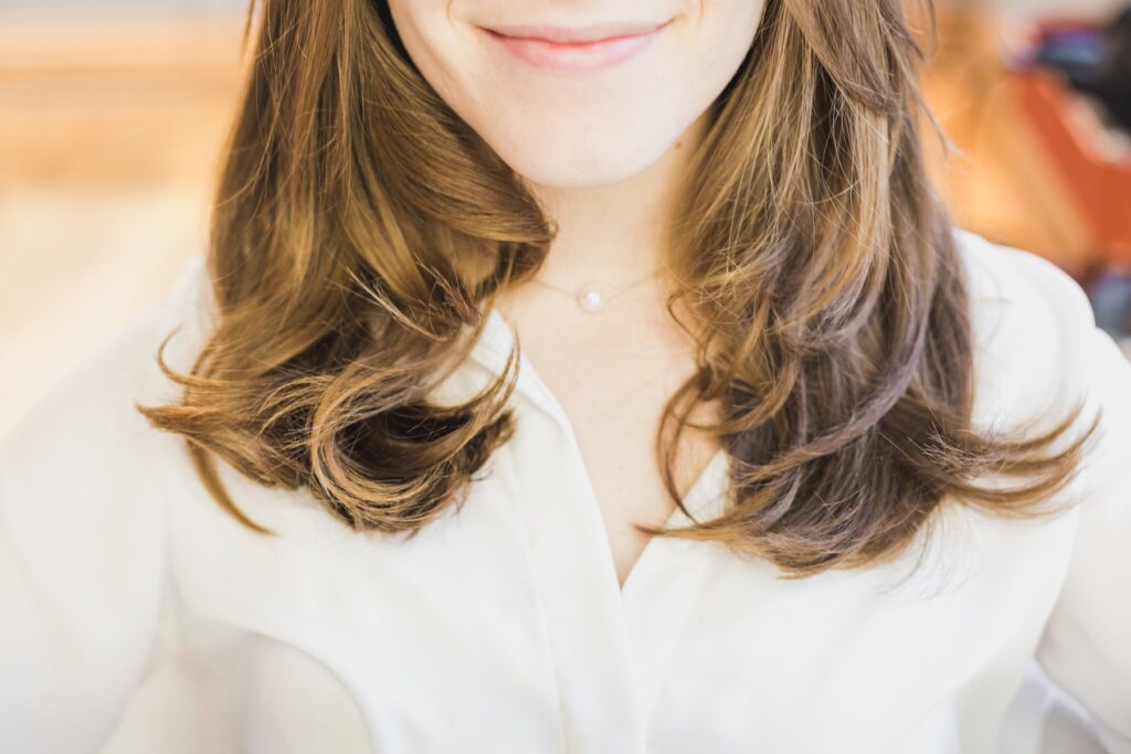 Mulher de cabelo ondulado com balayage mel