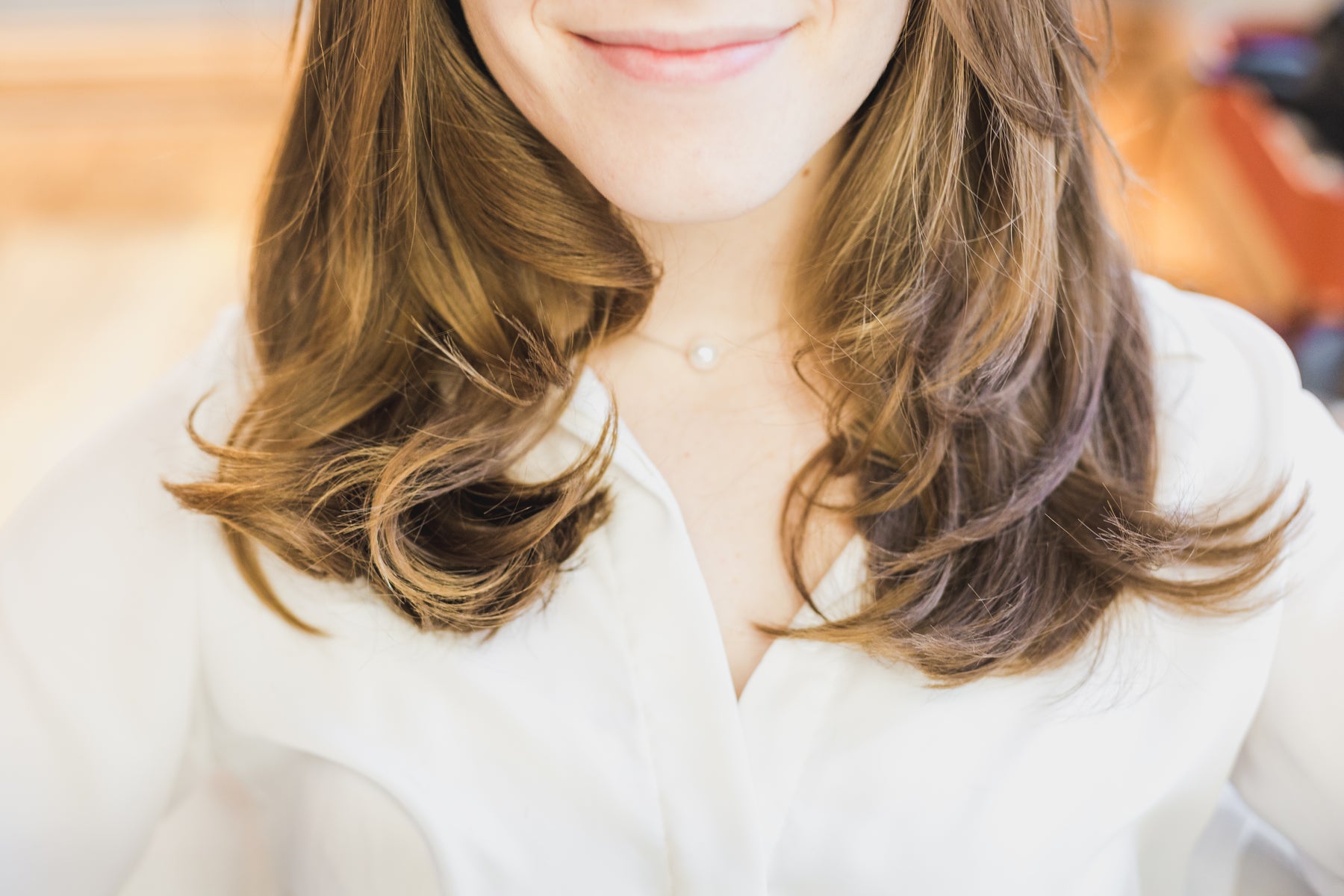 Mulher de cabelo ondulado com balayage mel